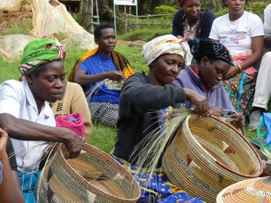 Local women demonstrating traditional basket weaving during a cultural experience in Uganda