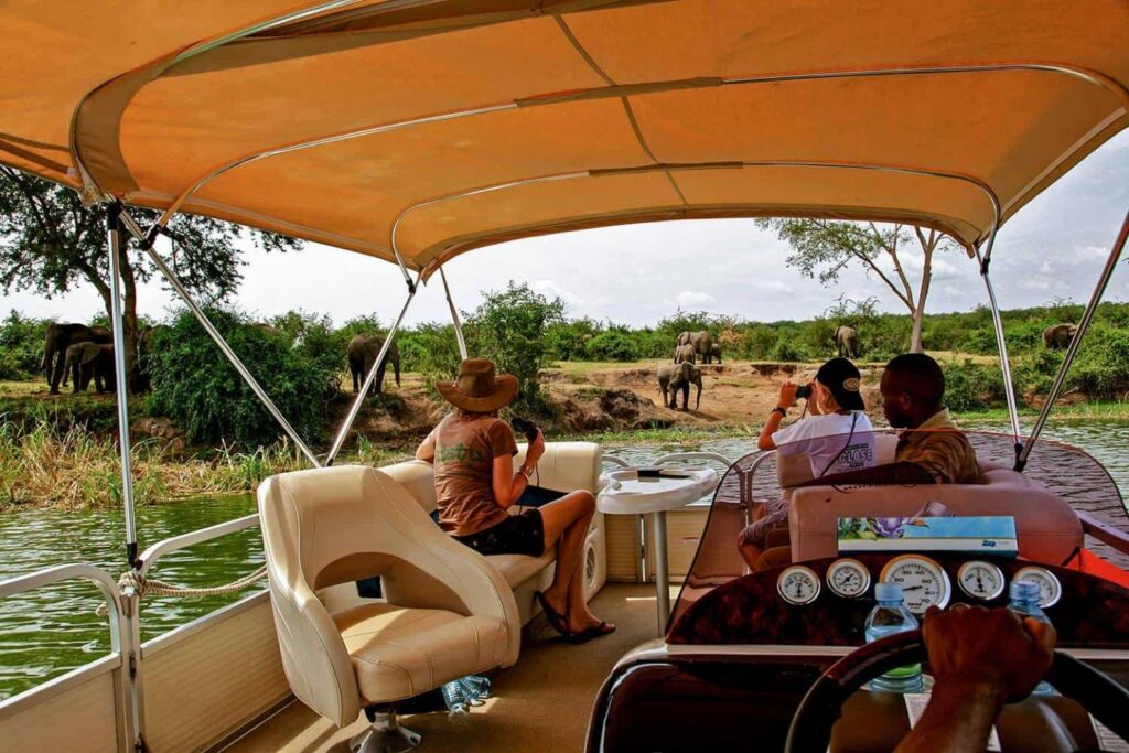 Uganda Wildlife Safaris featuring travellers viewing elephants during a boat cruise