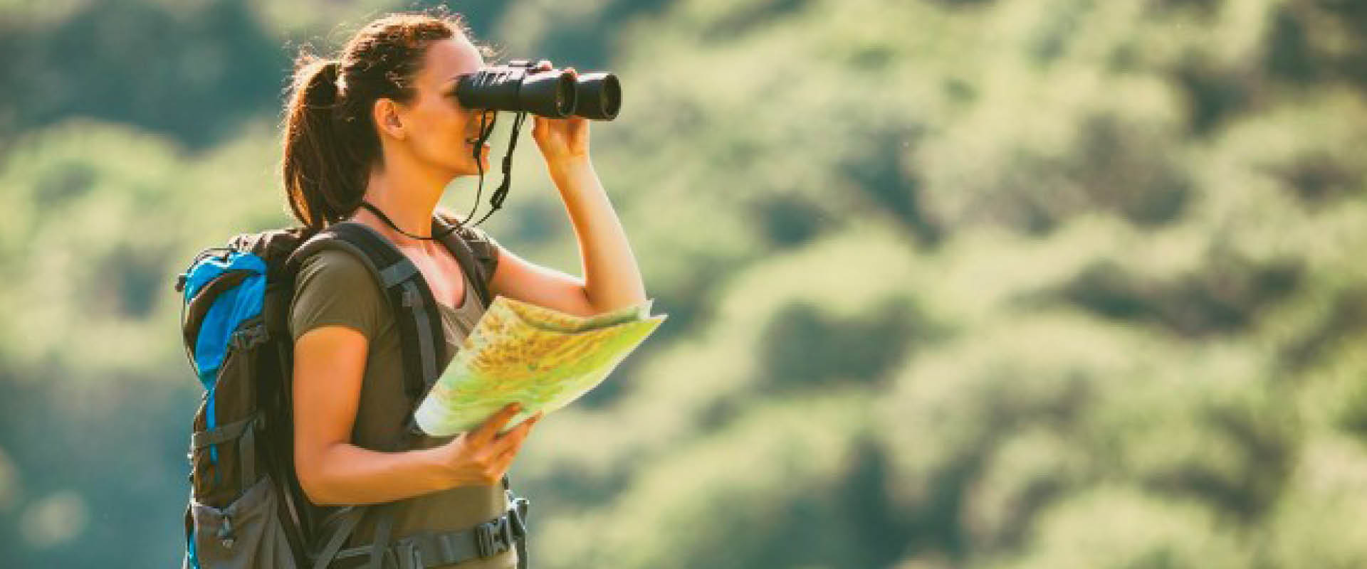 Birdwatcher observing colourful forest birds in Uganda using binoculars