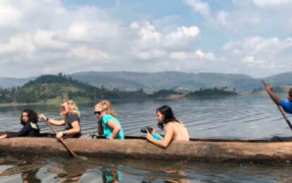 Travellers enjoying a traditional dugout canoe safari on Lake Bunyonyi in Uganda