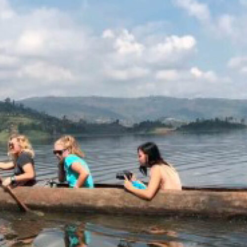 Travellers enjoying a traditional dugout canoe safari on Lake Bunyonyi in Uganda
