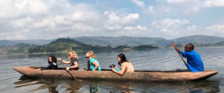 Travellers enjoying a traditional dugout canoe safari on Lake Bunyonyi in Uganda