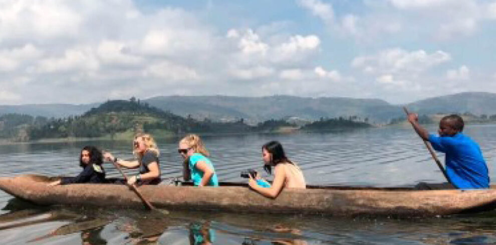 Travellers enjoying a traditional dugout canoe safari on Lake Bunyonyi in Uganda