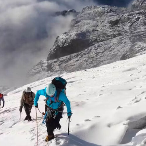 Climbers ascending the snow-covered slopes of the Rwenzori Mountains during a guided peak climbing expedition in Uganda