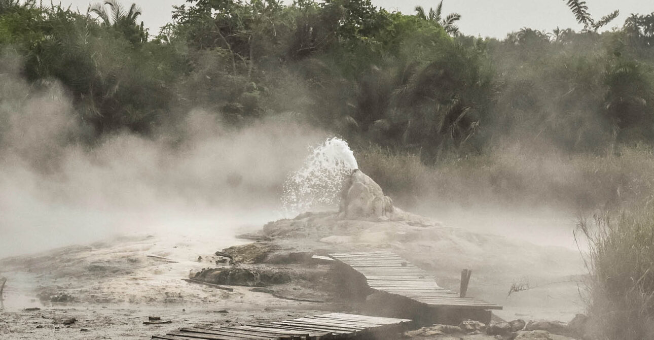Steam rising from the Sempaya Hot Springs in Semuliki National Park, western Uganda, surrounded by tropical rainforest.