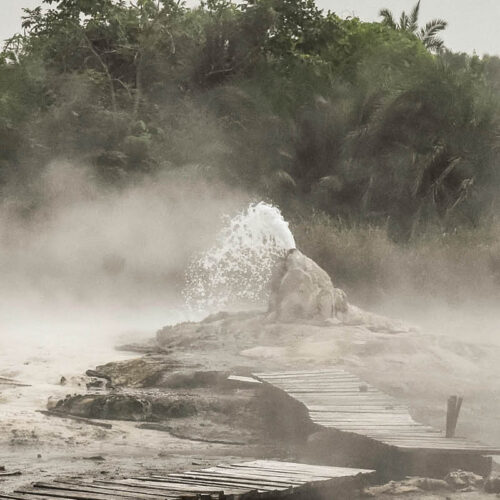 Steam rising from the Sempaya Hot Springs in Semuliki National Park, western Uganda, surrounded by tropical rainforest.