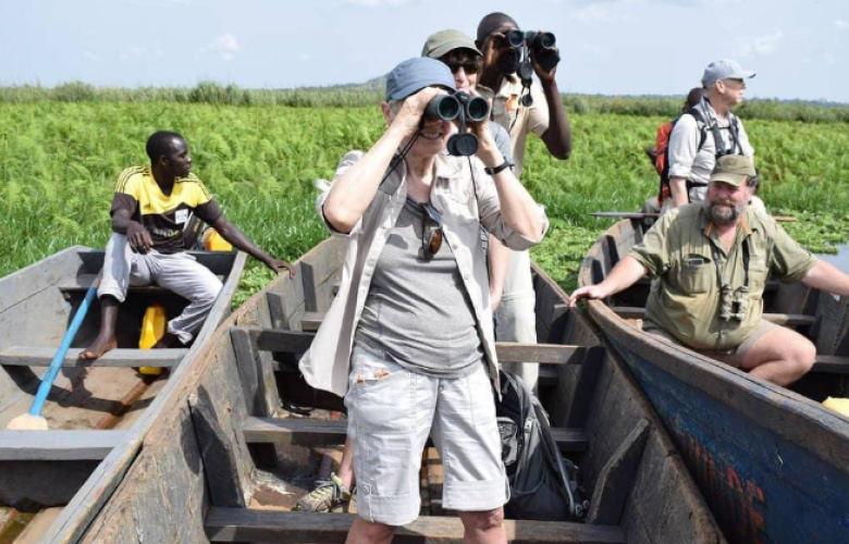 Birdwatchers exploring Mabamba Swamp by canoe in Uganda