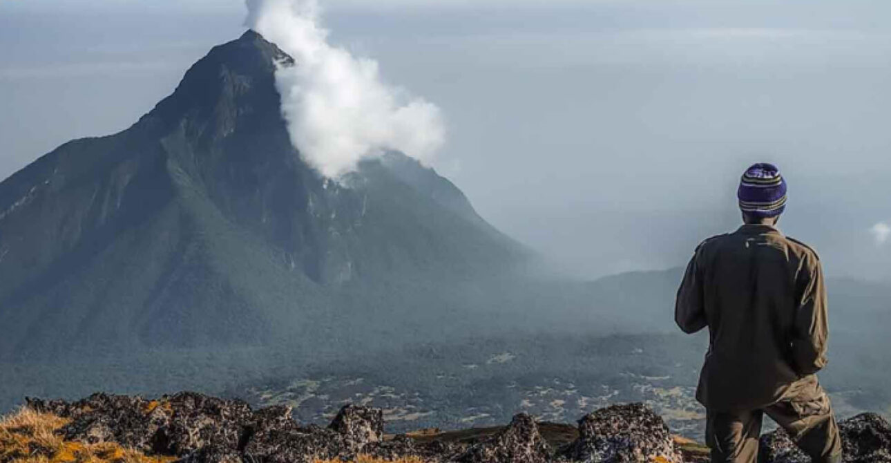 Hikers overlooking the crater lake on Mount Bisoke in Rwanda