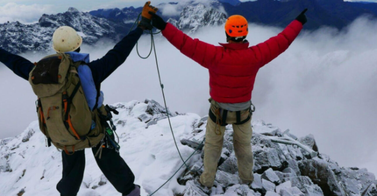 Climbers overlooking a snow-covered mountain landscape