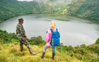 Travellers on a volcano hiking trail overlooking a crater lake