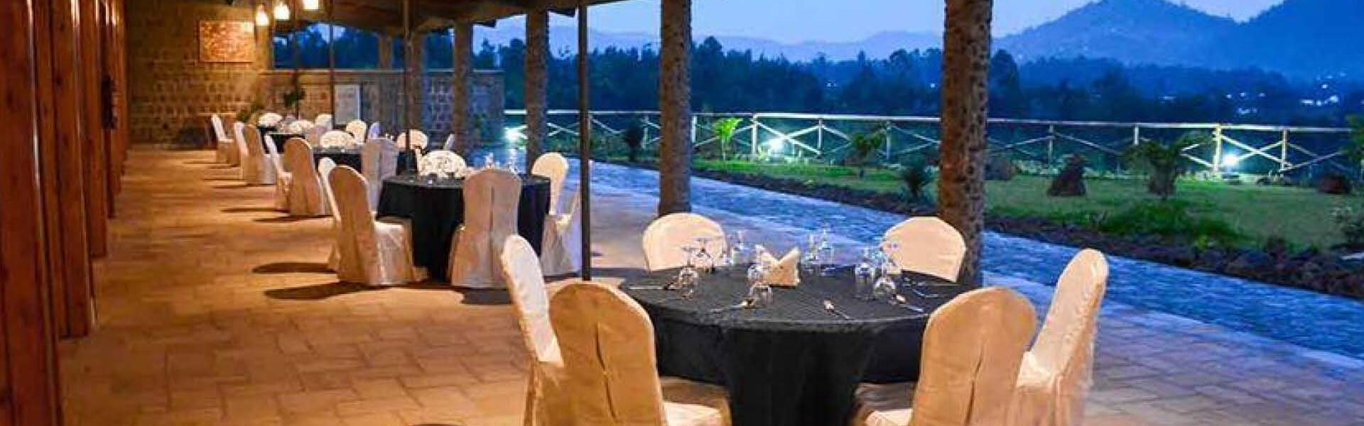 Premium safari lodge dining terrace with elegantly arranged tables, comfortable seating and scenic mountain views.