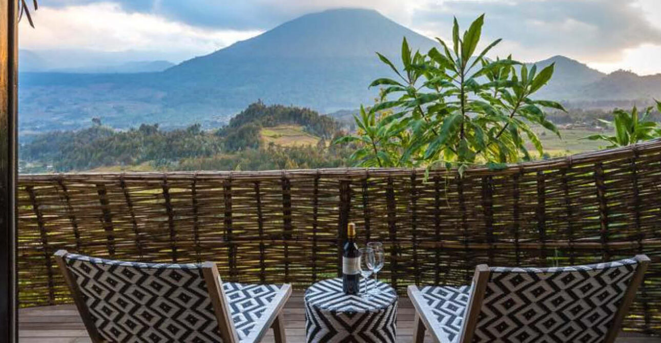 Private lodge terrace with two lounge chairs overlooking a mountain landscape in Rwanda.