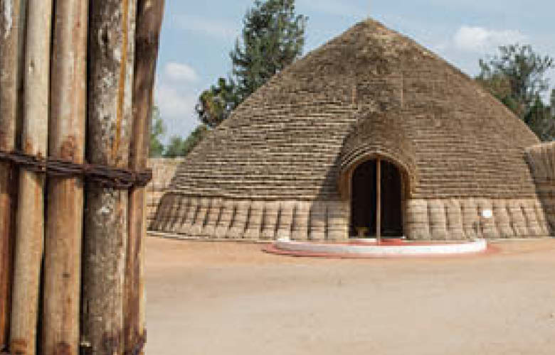 Safari packages in Uganda and Rwanda featuring traditional cultural architecture at a heritage site.